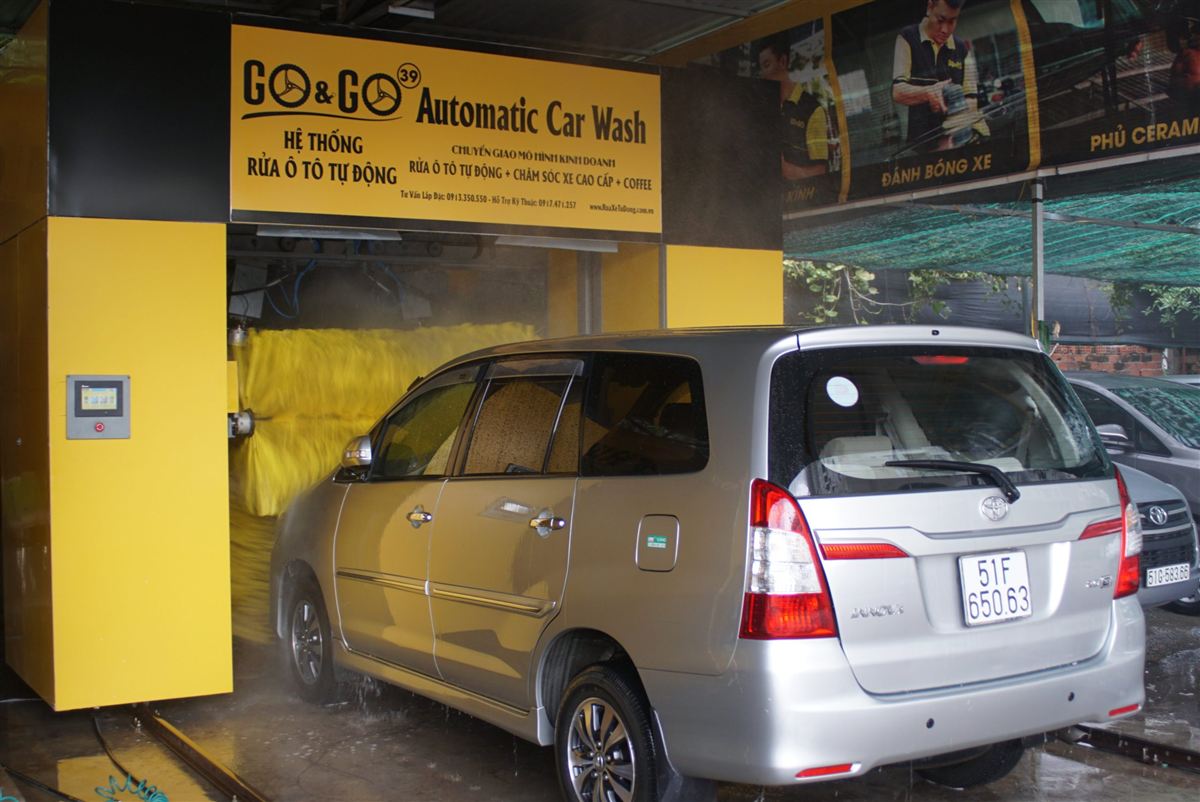 Automatic car wash machine washing an MPV with automatic size detection